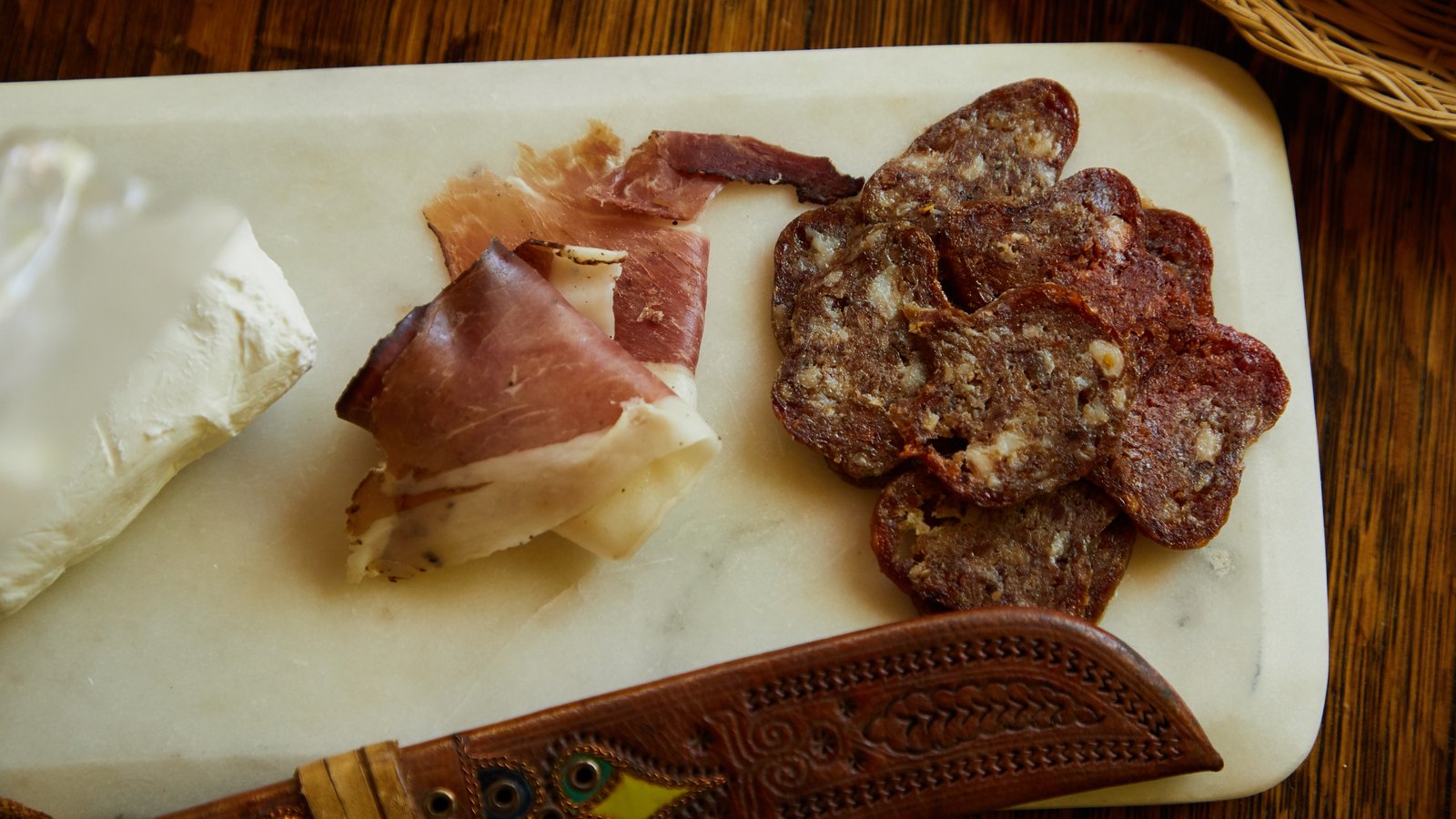 Elegant holiday charcuterie board with Colorado cured meats, cheeses, and fresh garnishes on marble.