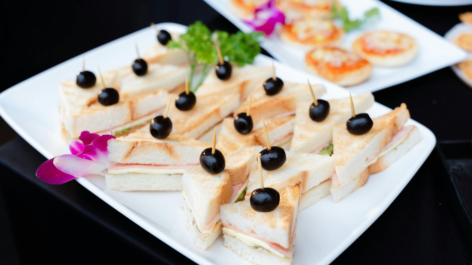 Elegant boxed lunch beside abundant buffet spread showcasing gourmet Denver catering options.