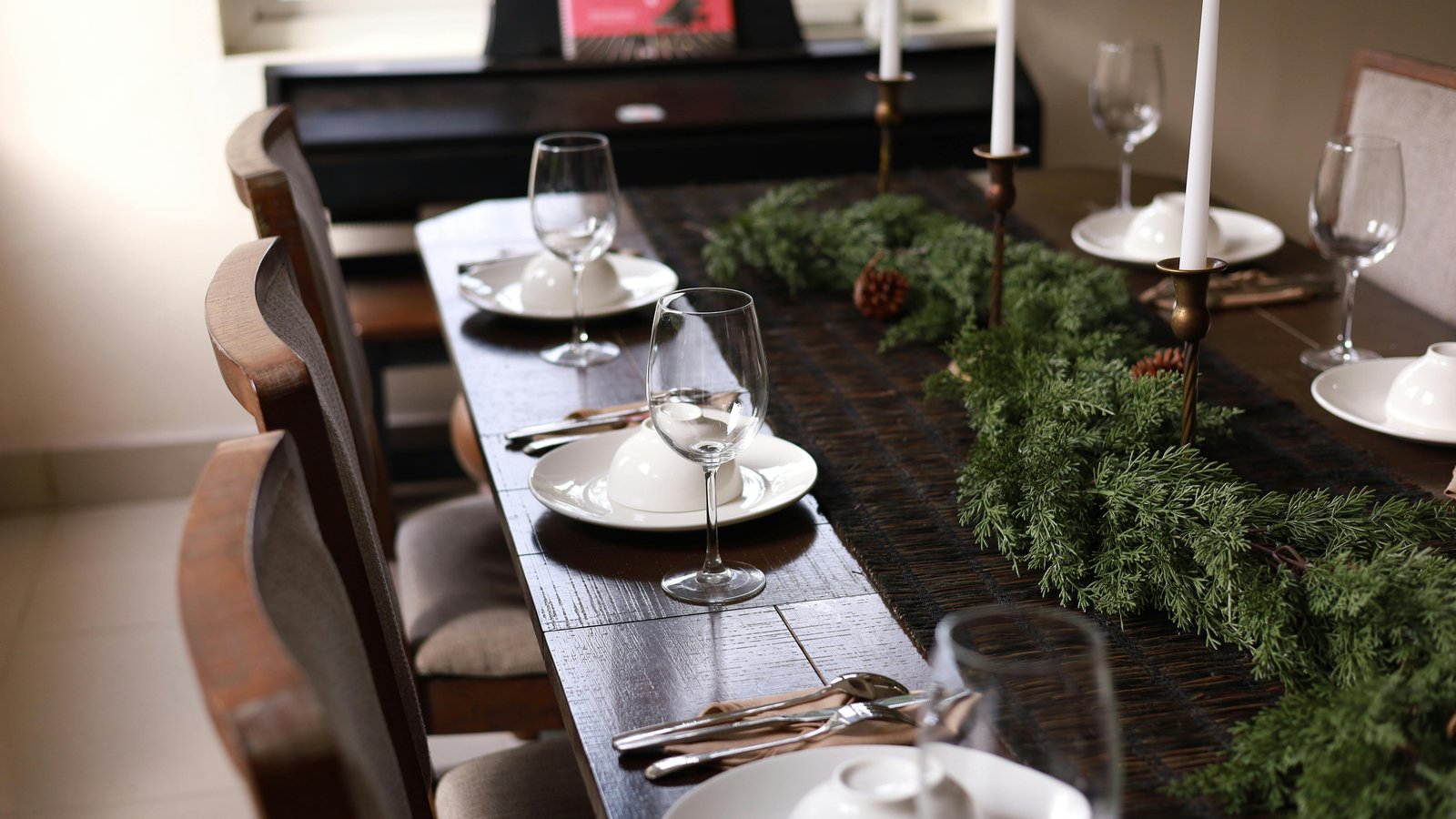 Elegant plated dinner service on a mountain home dining table with wine glasses and candlelight.