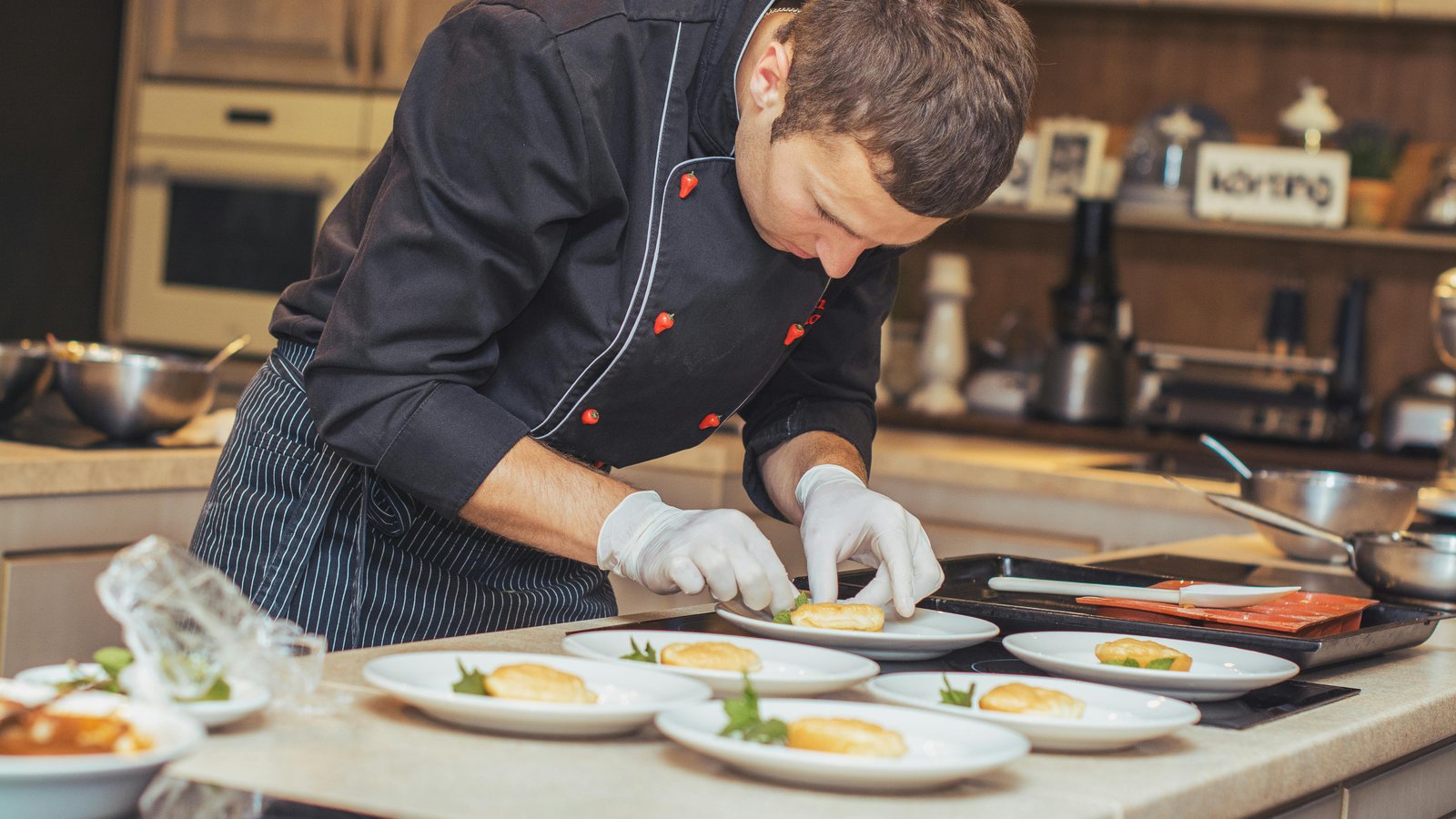 An elegant interactive food station with a chef plating dishes for Denver guests in formal attire.
