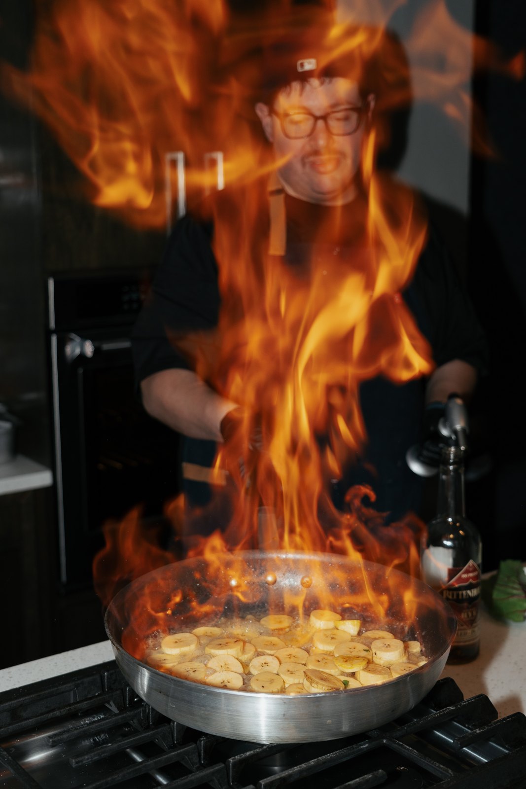 Chef Steve Ingber finishing a dish over an open flame