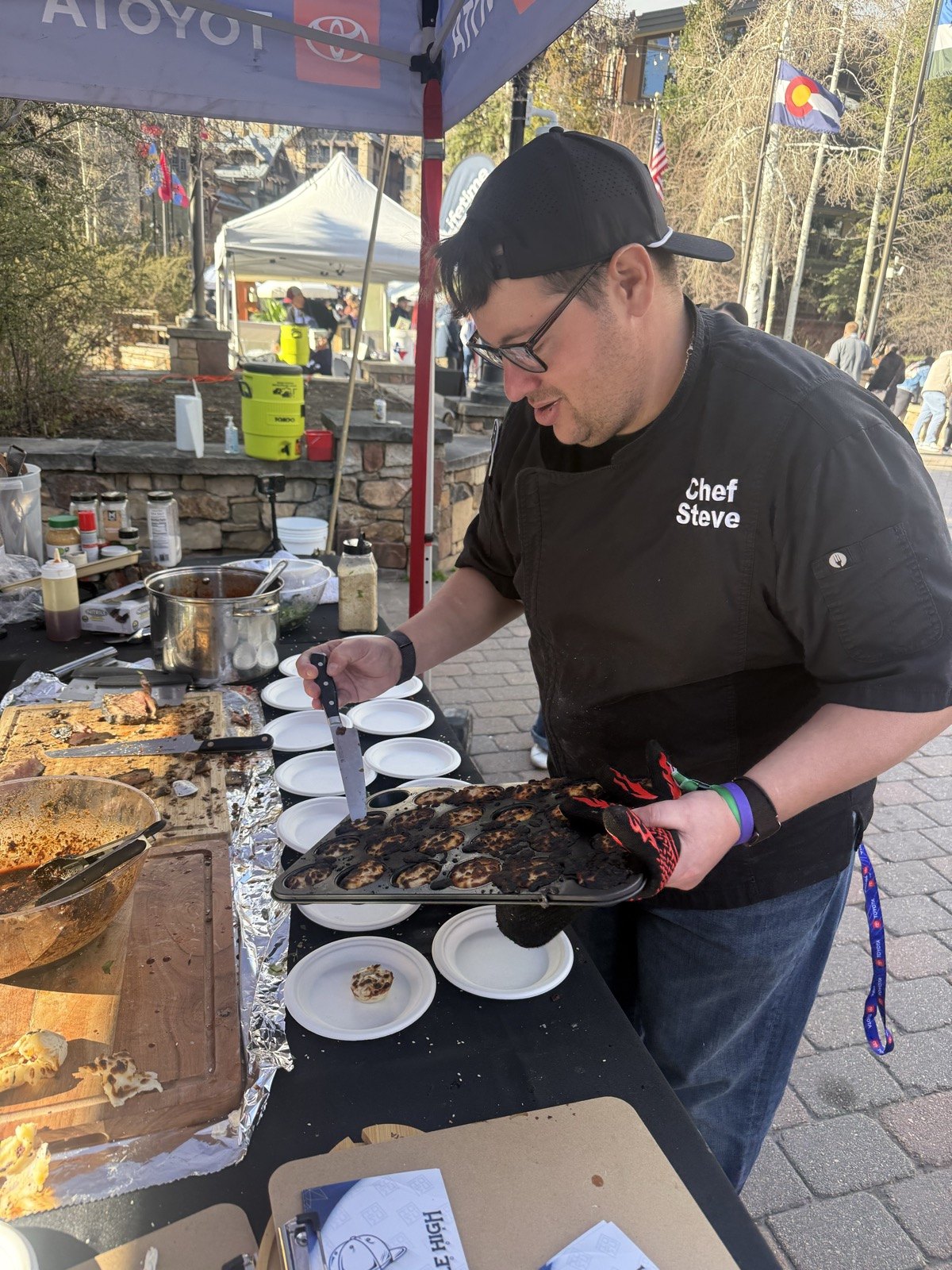 Chef serving plates at an outdoor tasting event