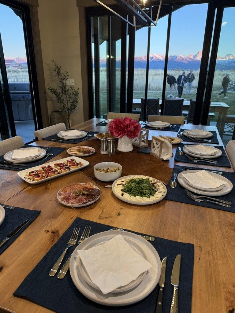 Dinner table set by the windows before guests arrive