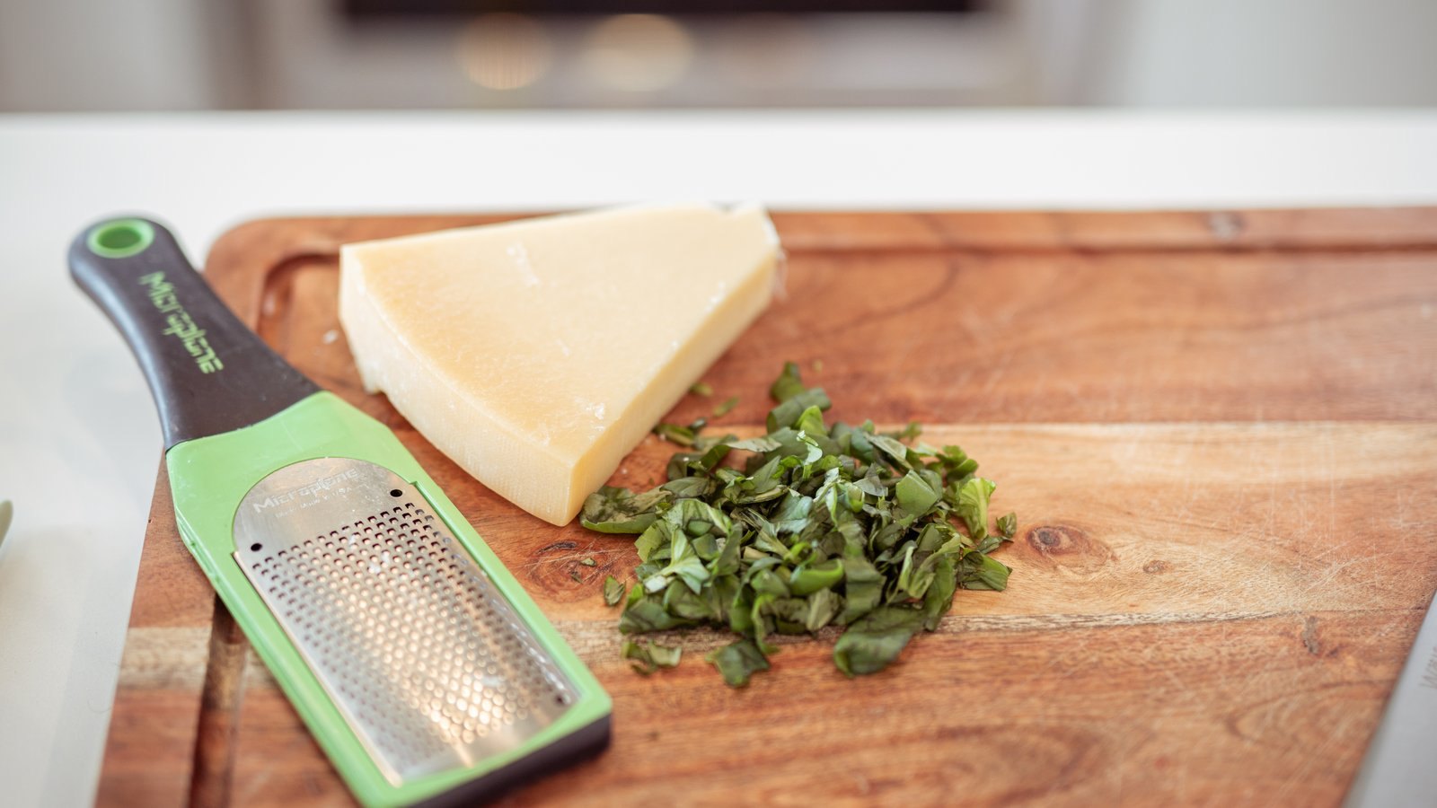 Fresh herbs and parmesan on a cutting board
