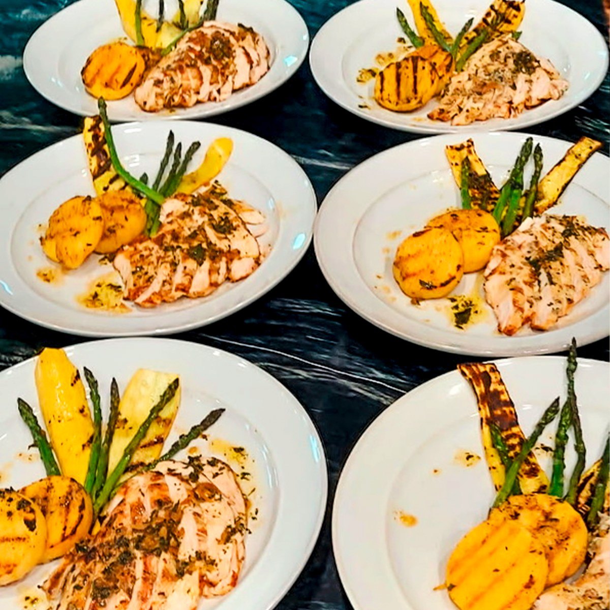 Plated chicken courses lined up for service